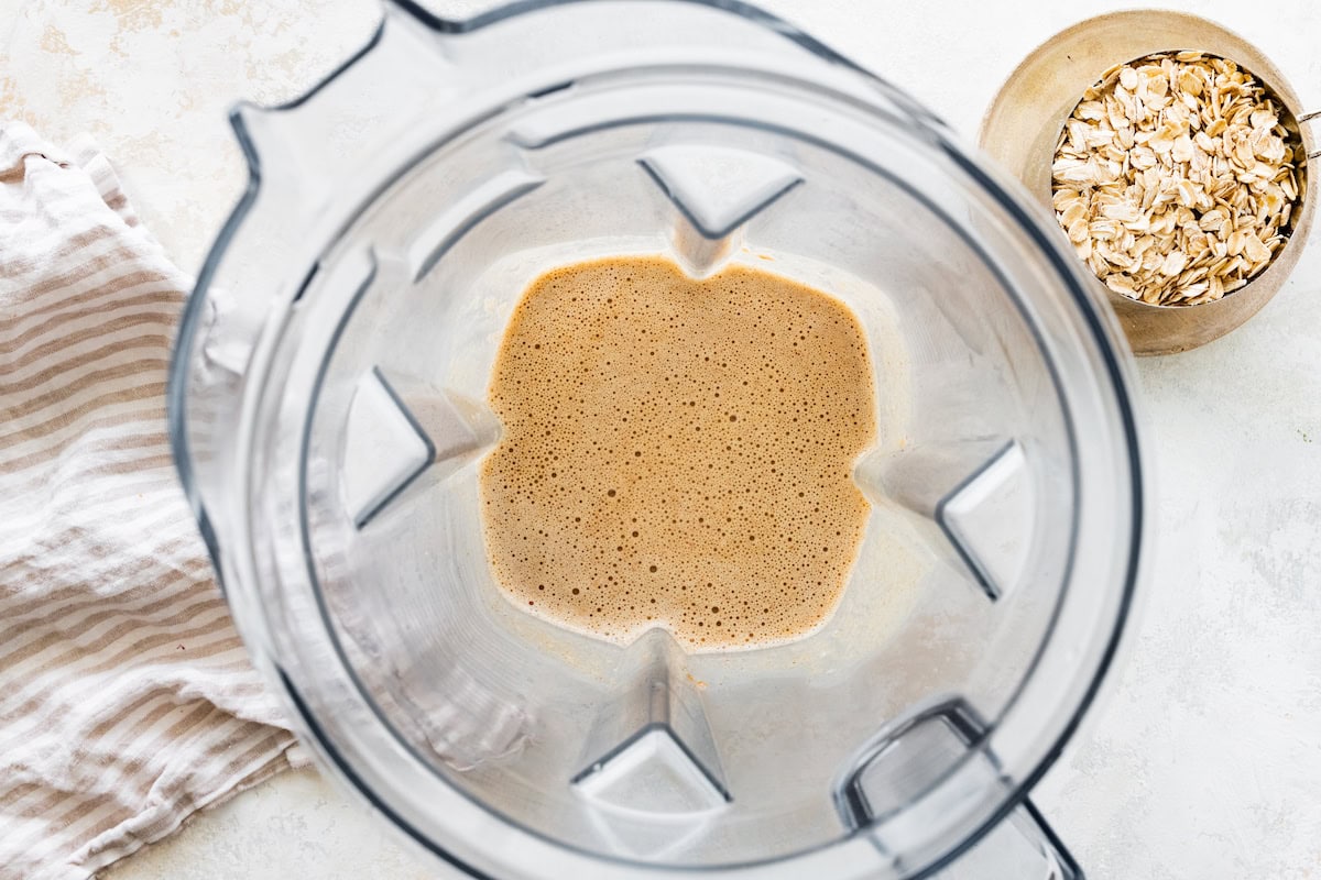 Dates, almond butter, and vanilla in a blender after being blended.