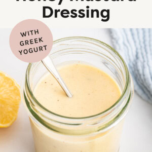 Creamy Honey Mustard Dressing in a jar with a spoon.