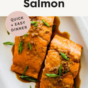 Two pieces of Maple Glazed Salmon on a platter and garnished with green onions.