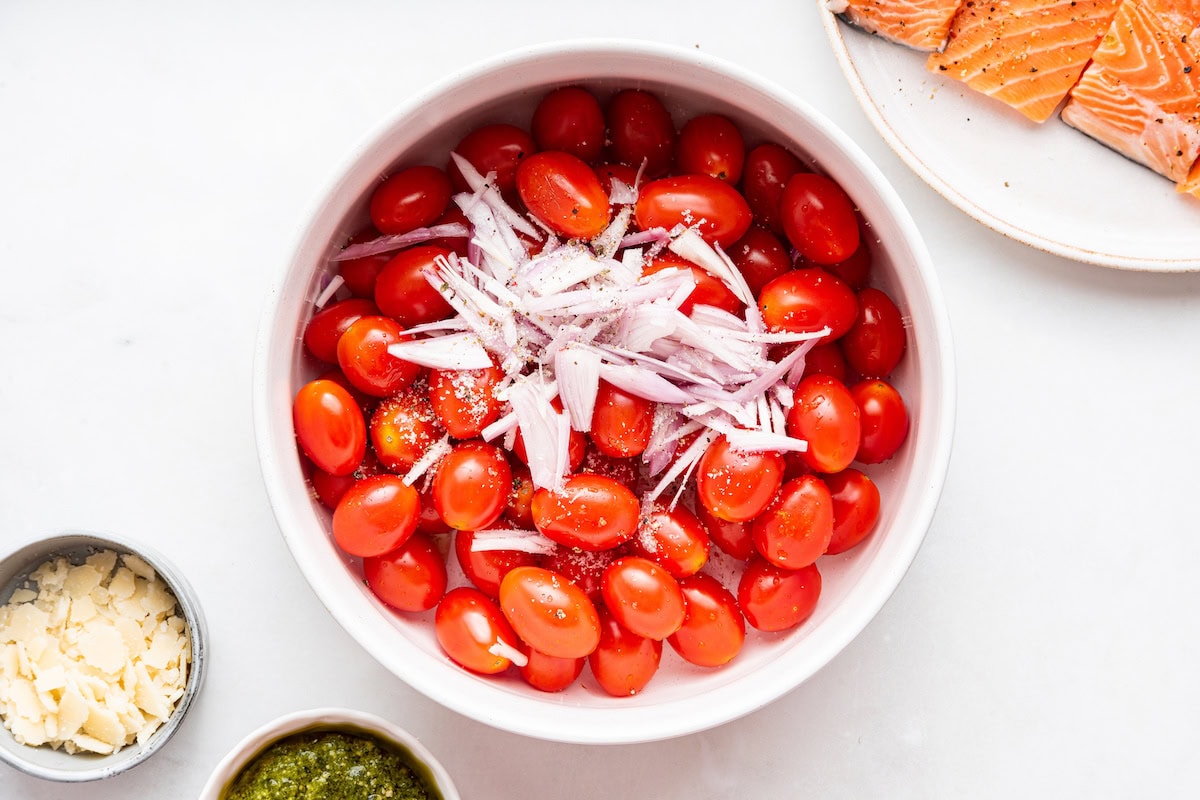 A bowl of cherry tomatoes and chopped shallots.